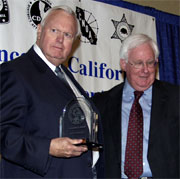 Detective Sergeant Jack Giroud (left) accepts his award from POST Commission Chairman Jim Fox